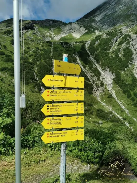Wegschilder Wegweiser mit mehrere Routen in den Bergen, gelbe Schilder mit Zielorten und Entfernungen.